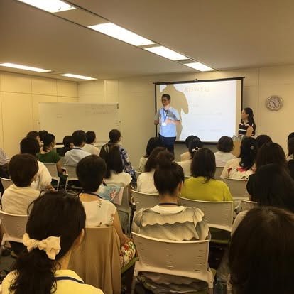 セミナーで登壇する潮田英之と、着席して話を聞く参加者たち